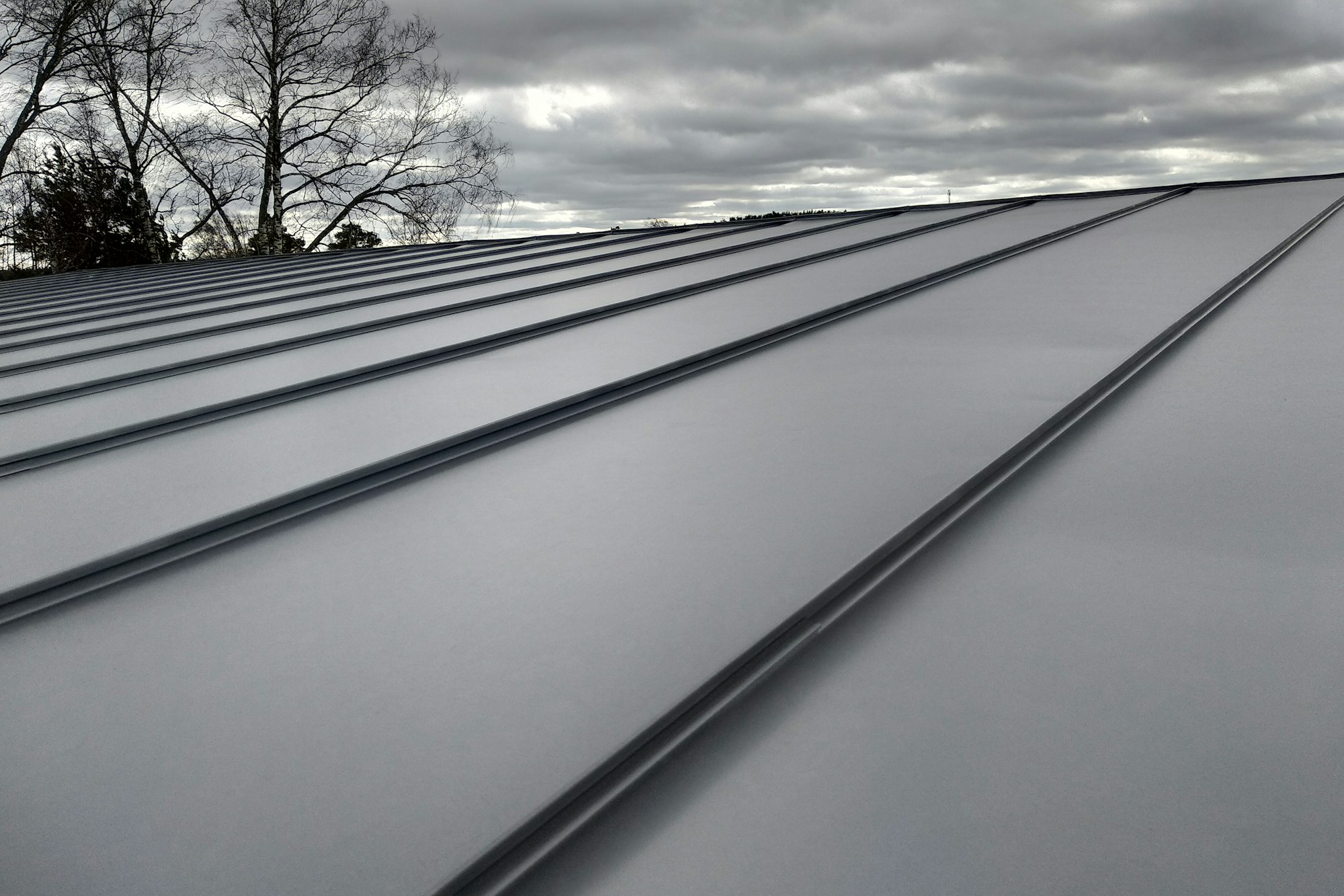 Close-up detail of house roof made from gray metal sheets.